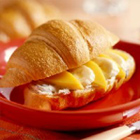 Croissant met verse abrikoos, banaan en hazelnoten