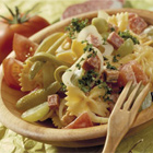 Pastasalade met tomaat, ham, salami en olijven