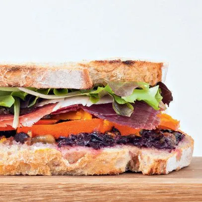 Landbrood sandwich met rauwe ham, druiven en muskaatpompoen