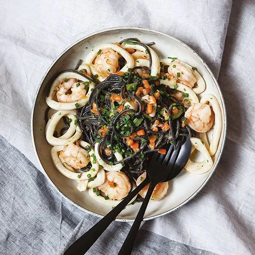 Zwarte spaghetti met inktvisringen en garnalen