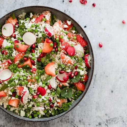 'Bloemkool-couscous' salade met aardbeien en granaatappelpitten