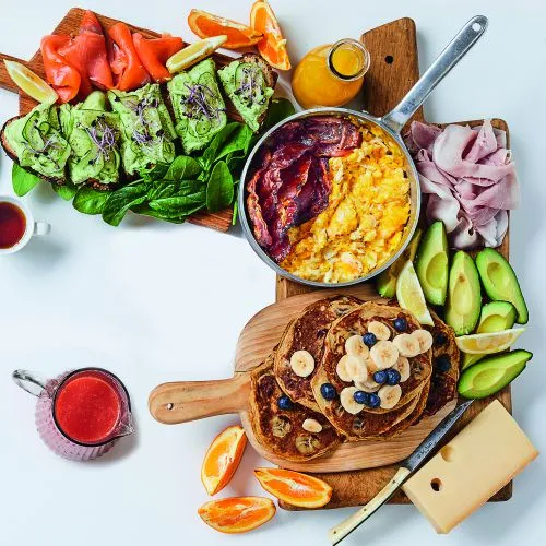 Brunchplank: roerei, brood met avocado, pannenkoeken met fruit