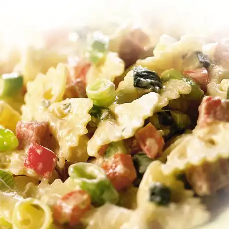 Farfalle met courgette, bosuitjes, paprika en salami