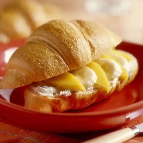 Croissant met verse abrikoos, banaan en hazelnoten