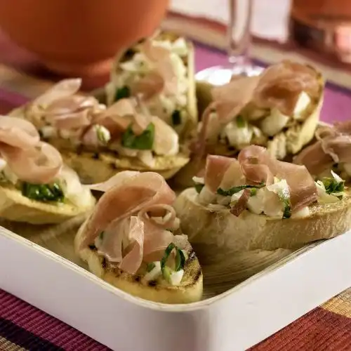 Crostini met rauwe ham en kruidige perensalsa